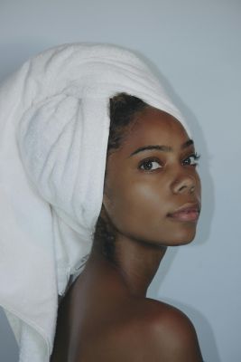 Portrait of a woman with towel wrapped hair, showcasing elegance and natural beauty.