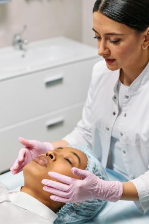 A cosmetologist cares for a client during a facial in a medical clinic. Professional beauty treatment indoors.