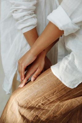 Elegant close-up of hands resting gently on a textured fabric, conveying warmth and style.